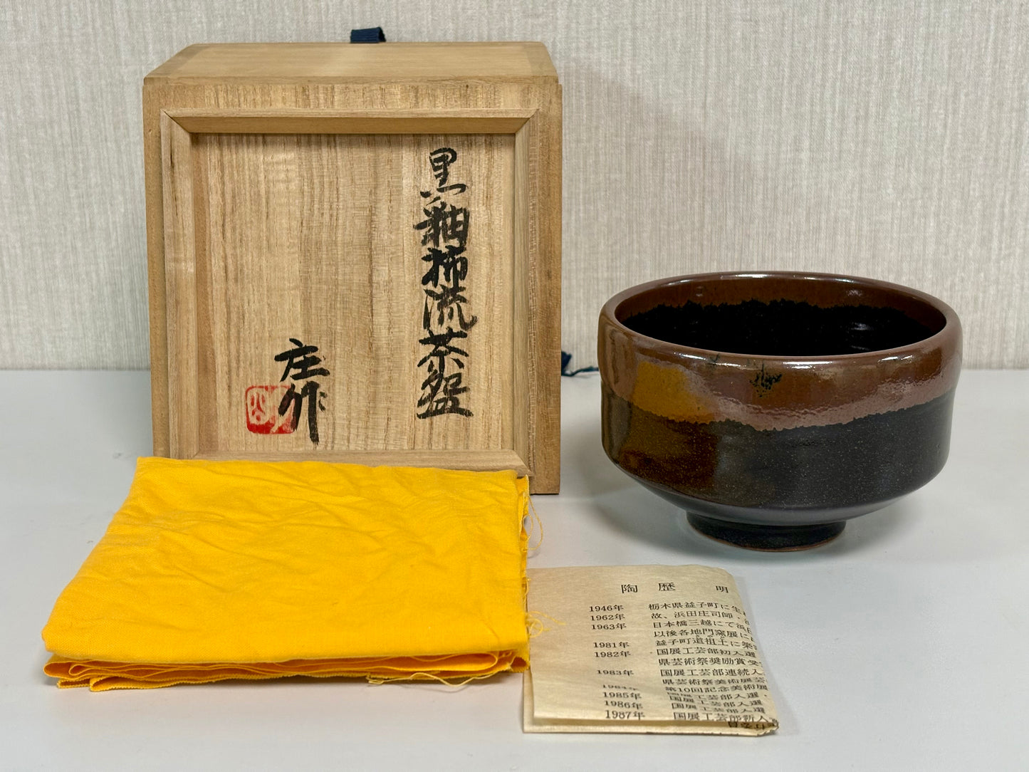 SBKTB287	明石庄造　黒釉　柿流　茶碗